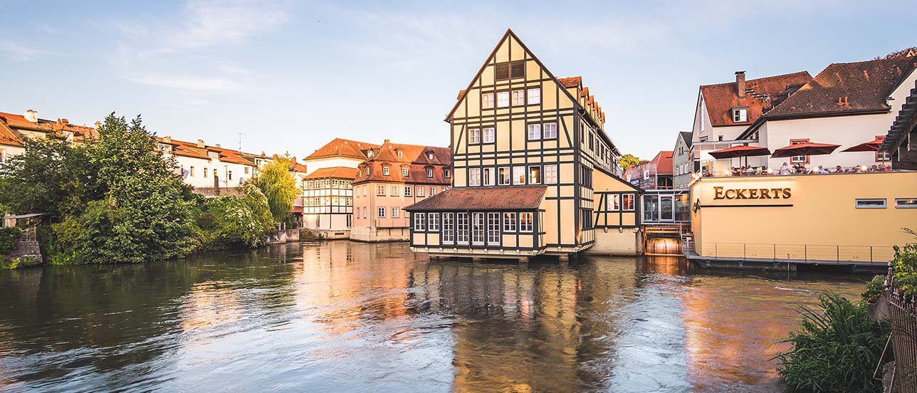 Blick über den Fluss Regnitz auf das Eckerts Wirtshaus und die Dachterrasse